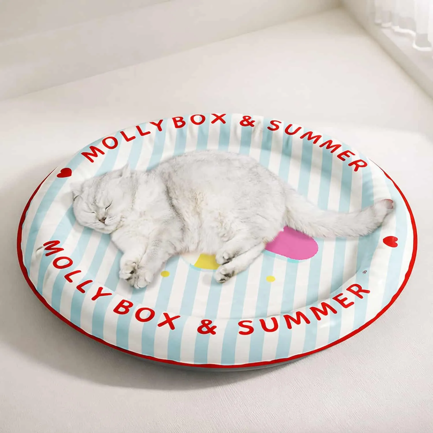 Round pet cooling bed with blue and white striped design, cartoon kitty print, red trim, and bolster walls around a cool center