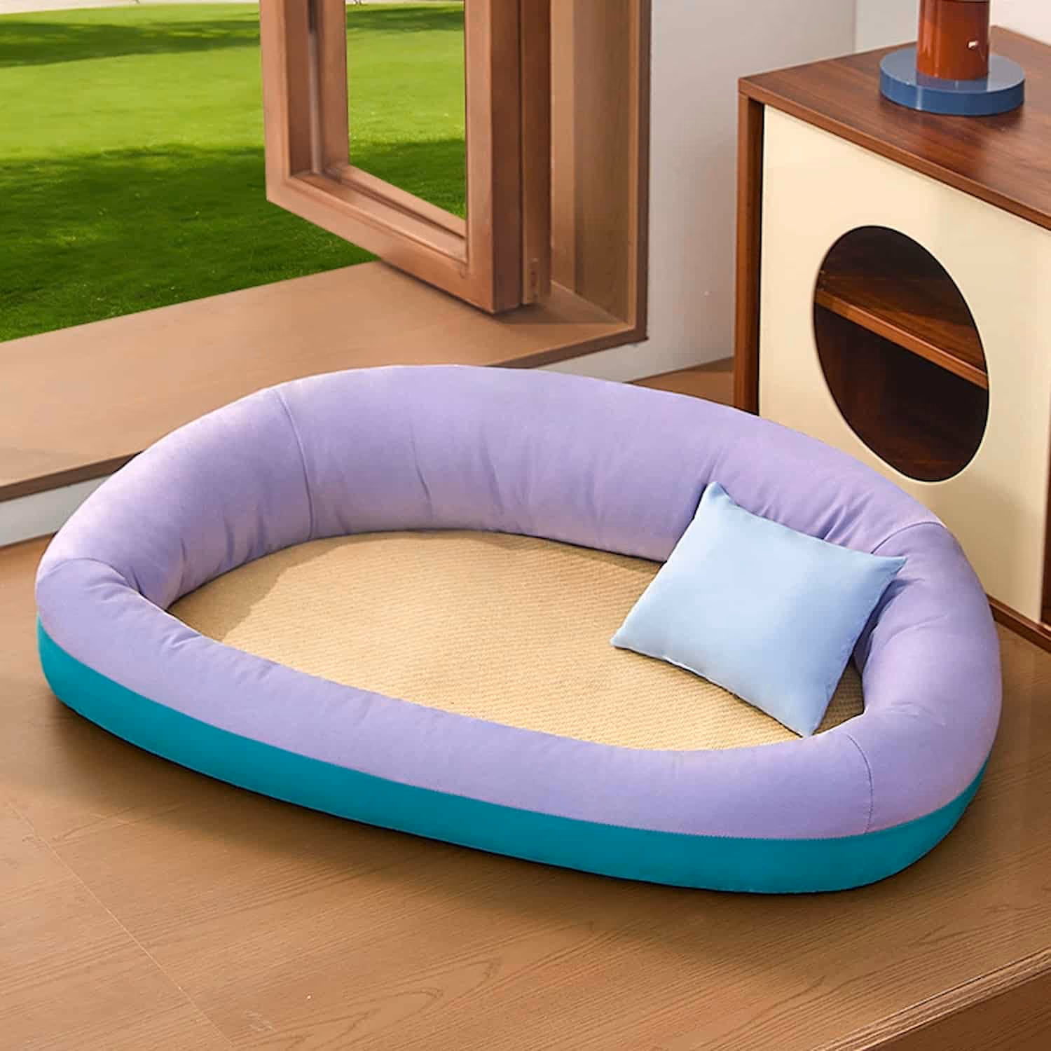 Oval cat cooling bed with natural rattan mat center and raised bolster edges