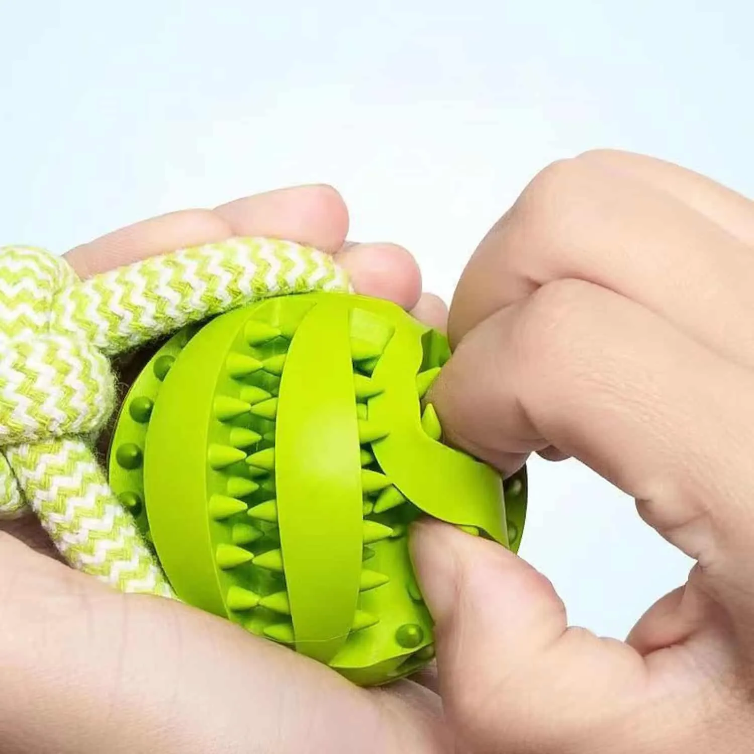 TPR rubber treat ball with ridged surface on a braided cotton rope handle in blue and green, shown with a Corgi